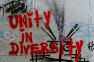 Graffiti mit der Aufschrift „Unity in Diversity“ auf einer Betonwand. Die Botschaft „Einheit in Vielfalt“ steht im Mittelpunkt und verweist auf die Bedeutung von Zusammenhalt, Respekt und dem konstruktiven Umgang mit unterschiedlichen Perspektiven in einer vielfältigen Gesellschaft.